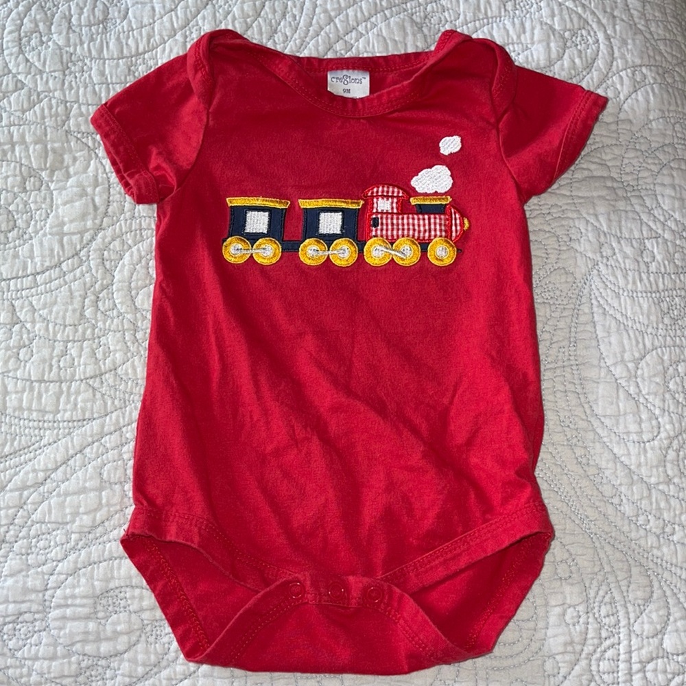 One piece red with train appliqué and Embroidery. 9 months
